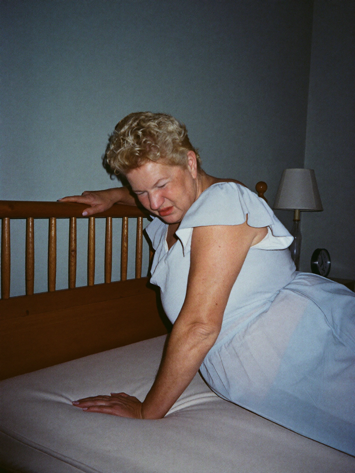 Woman gripping the headboard, dizzy in bed